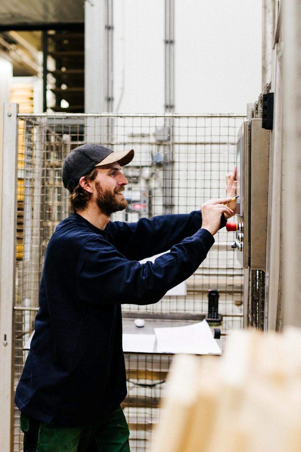 Een man die in de productie werkt. Hij is in zijn werkplaats bezig.