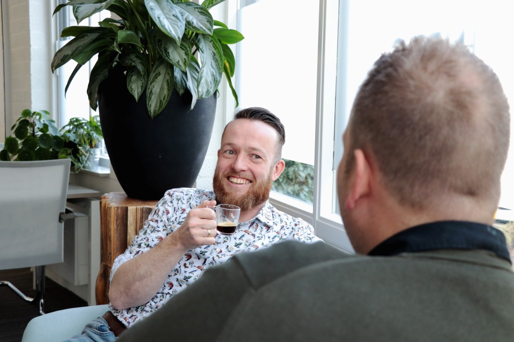 Een recruiter en een kandidaat die een kop koffie met elkaar drinken